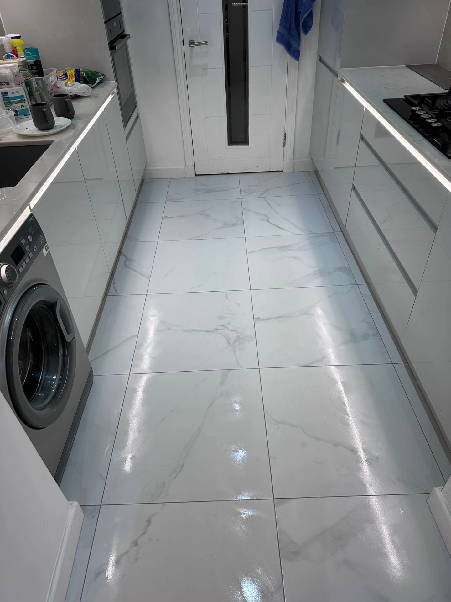 Galley kitchen with polished marble-effect porcelain floor tiles